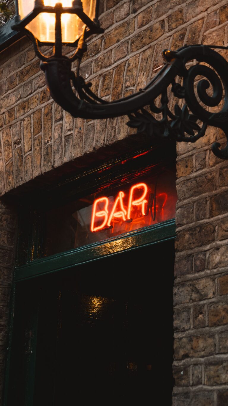Außenansicht einer Bar mit einem leuchtenden roten Schild