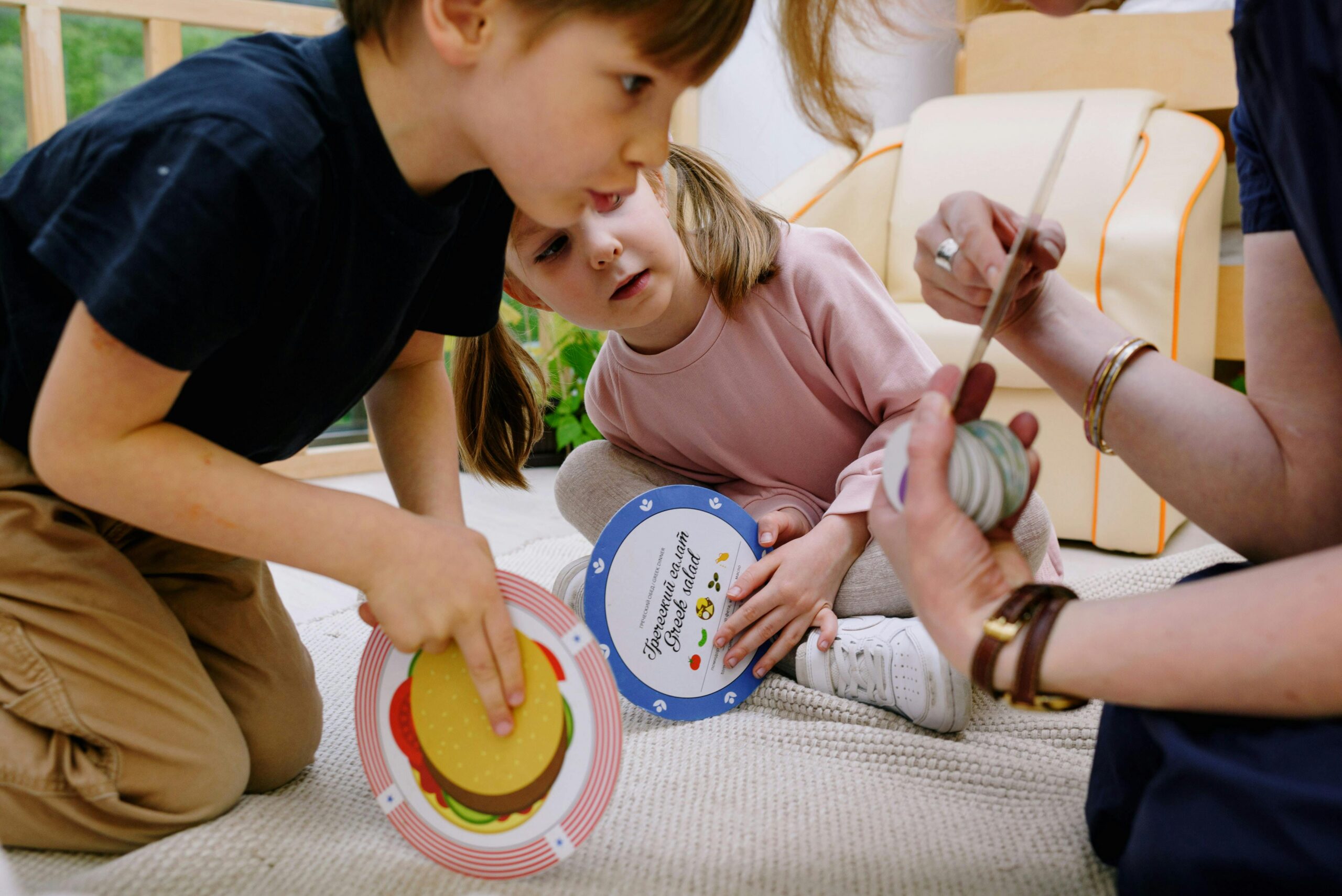 Logopädin mit zwei Kindern und Wort- und Bilderkarten