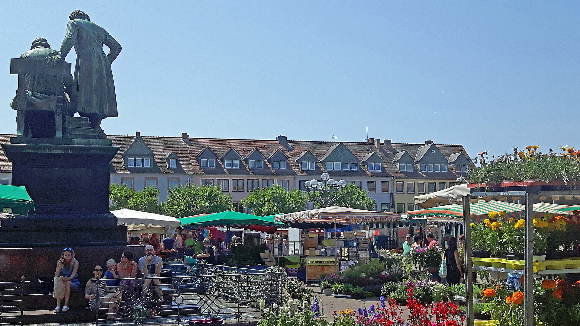 Wochenmarkt auf dem Marktplatz in Hanau mit dem Brüder-Grimm-Denkmal