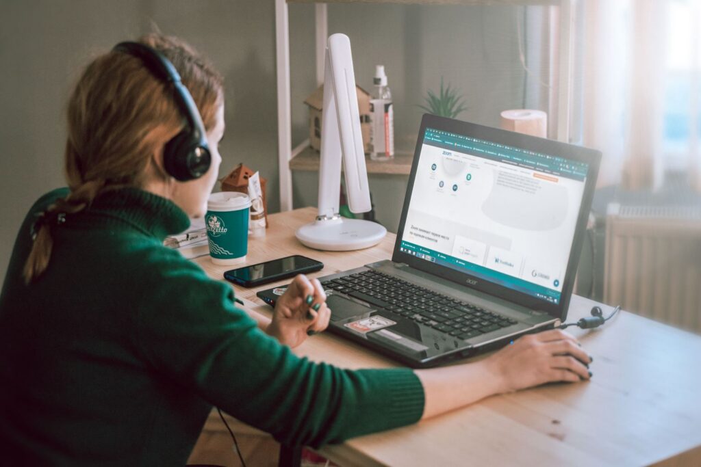 Virtuelle Assistentin mit Kopfhörern in einem Videocall am Schreibtisch