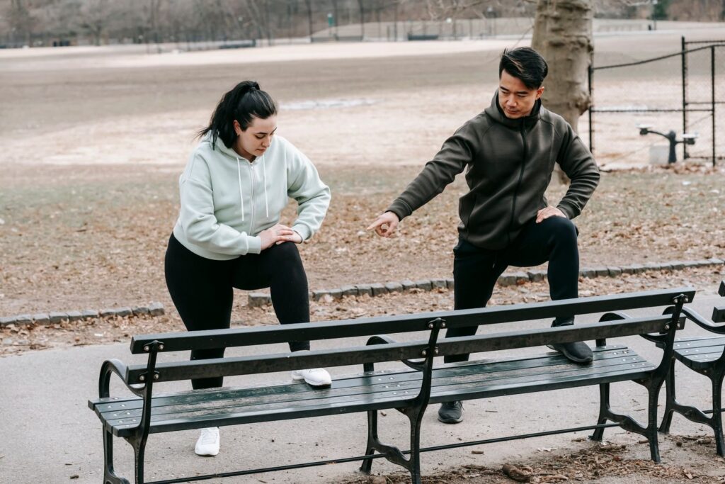 Personal Trainer begleitet eine Kundin beim Training im Park